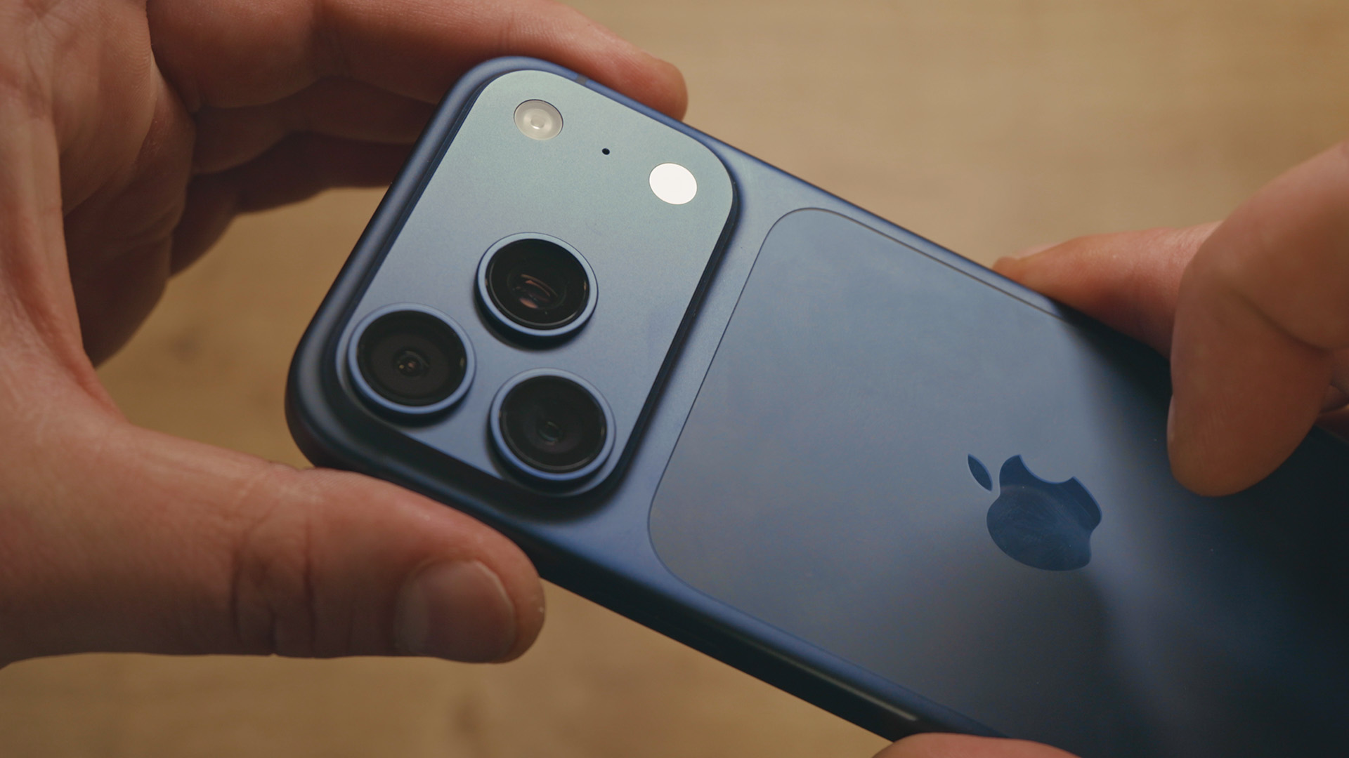 Pogled na novi iPhone 17 pro gdje ga osoba drži u ruci kako bi pozala novi dizajn i plavu boju uređaja. 